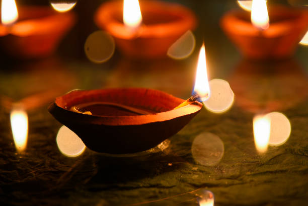 istock Happy Diwali - Diya lamps lit during diwali celebration 1347725834