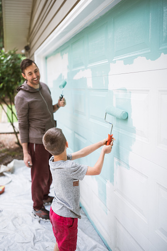 A dad and his child bond as they enjoy togetherness working on getting their home exterior painted.  A fun project for the family and opportunity for the child to grow in responsibility.
