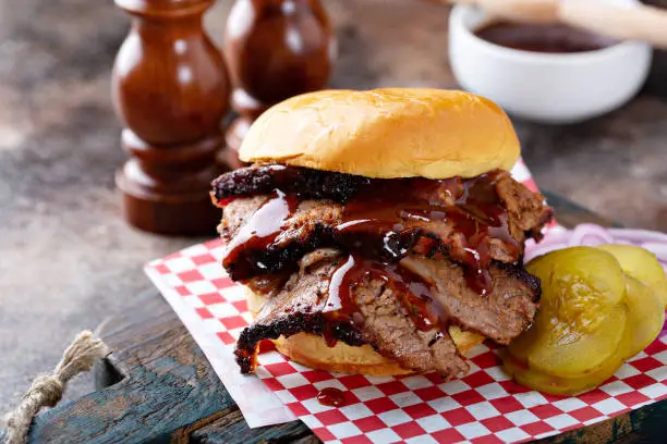 Smoked barbeque beef brisket sandwich with pickles and bbq sauce