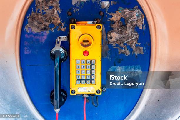 Old Rusted Blue Telephone Booth With Old Yellow Phone Inside Stock Photo - Download Image Now