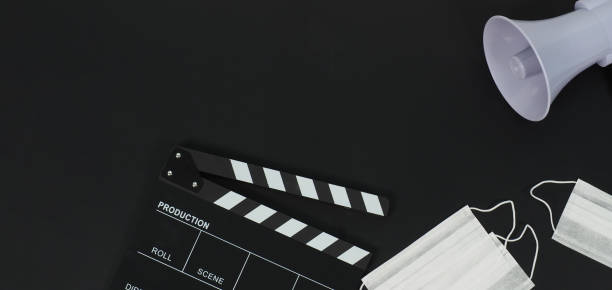 istock Black clapper board or movie slate and face mask ,magaphone on black background. 1347730268