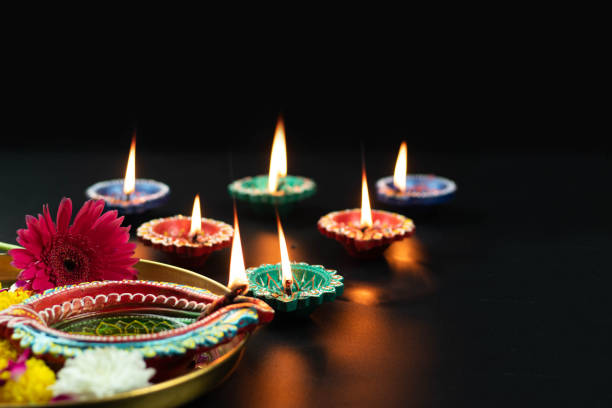 istock Various Size Handmade Clay Diya, Deep Or Dia Illuminated In Dark And Golden Thali Decorated With Phool Flowers. Theme For Diwali Pooja, Navratri, Dussehra Puja, Deepawali Or Shubh Deepavali 1347742183