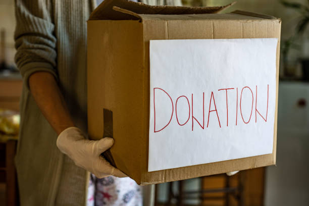 istock Senior woman holding donation box 1347742311