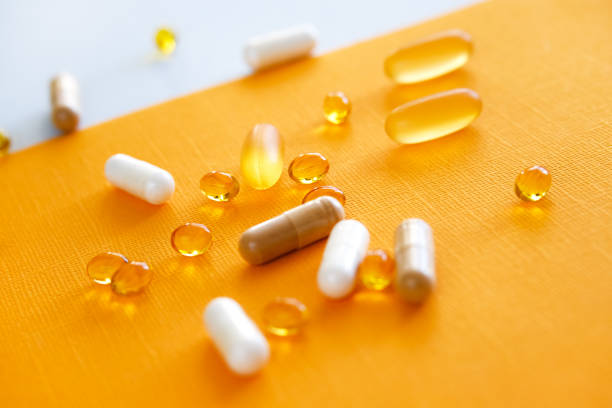 желтые капсулы нутрицевтиков в ложке. таблетки и медикаменты. - lecithin стоковые фото и изображения