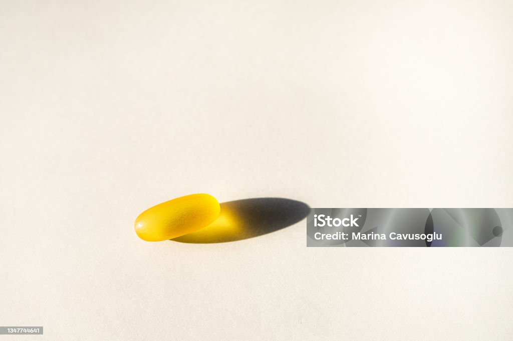 Yellow capsules of nutraceuticals in spoon. Pills and meds. Yellow gel capsules of nutraceuticals in spoon. Pills and meds assortment. Acid Stock Photo