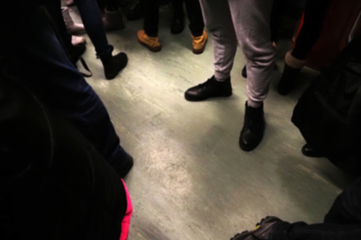 Feet in a circle, blurred background. People on public transport