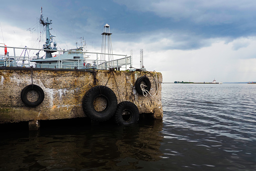Old concrete pier, mooring berth with car tires for mooring boats and yachts. Winter pier, old part of the city of Kronstadt, St. Petersburg, Russia
