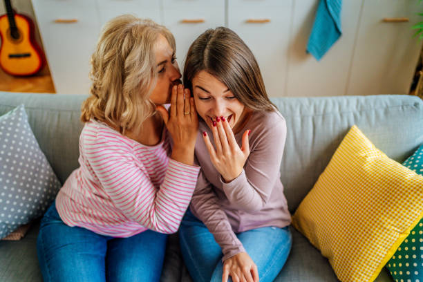 istock Mother telling secret to surprised daughter 1347748206
