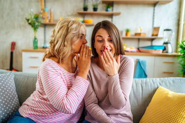istock Mother telling secret to surprised daughter 1347748388