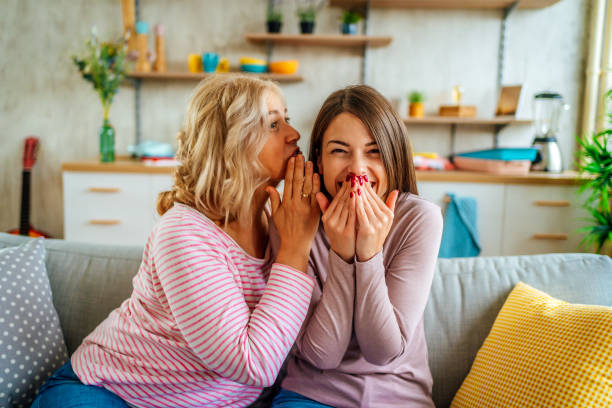 istock Mother telling secret to surprised daughter 1347748467