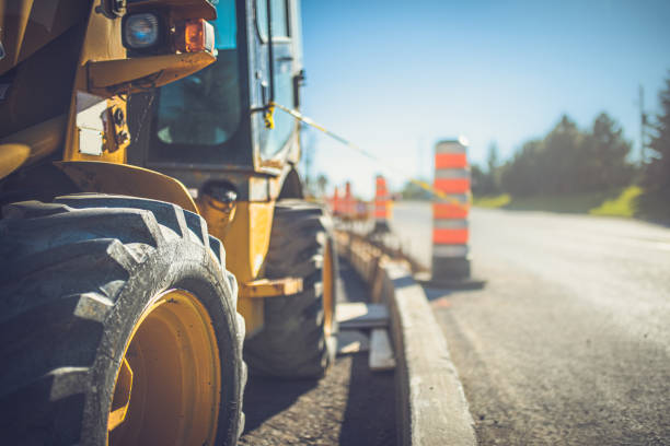 gelber traktor auf einer baustelle - road construction stock-fotos und bilder