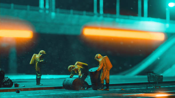 istock Workers with protective suits transport big barrels at night 1347758535