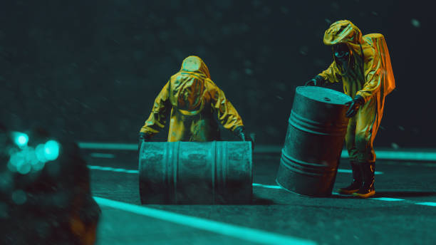 istock Two workers with yellow protective workwear transport big barrels at night 1347758562