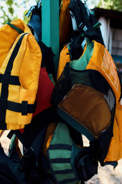 istock Colorful life vests hanging on hangers on coast 1347759875