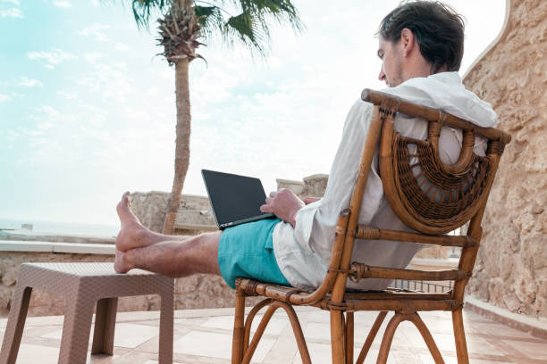 istock freelancer with a laptop in his hands works on vacation 1347766364