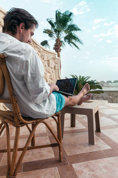 istock freelancer with a laptop in his hands works on vacation 1347766365