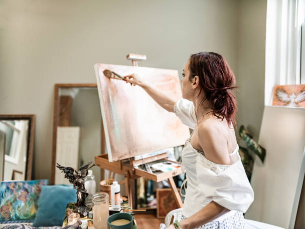 istock Young Caucasian woman painting in studio 1347767780