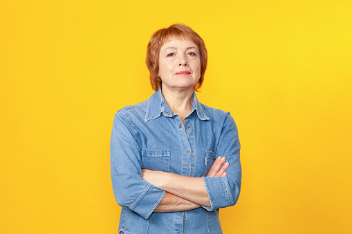 Retrato de estudio de cerca de una atractiva mujer de 60 años con el pelo rojo corto photo