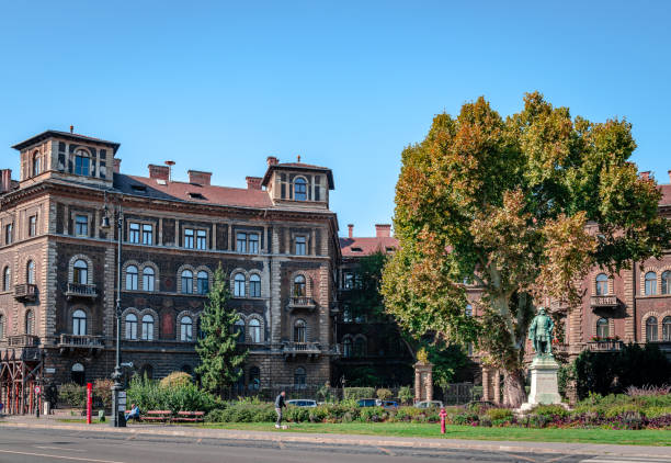 Budapest, Hungary - 6 October 2018: Beautiful old painted buildings at Kodaly Korond with the statue of Gyorgy Szondy. Kodaly Korond is the intersection of Andrassy Ave and Szinyei Merse utca.