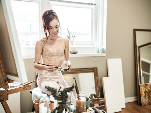 istock Young Caucasian woman painting in studio 1347768645