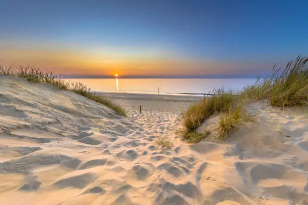 Inviting Sunset View over ocean from dune over North Sea and Canal in Ouddorp, Zeeland Province, the Netherlands. Outdoor scene of coast in nature of Europe.