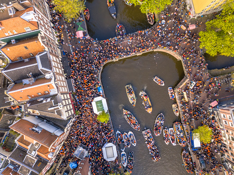 Canal boat parade on Koningsdag Kings day festivities in Amsterdam. Birthday of the king. Seen from helicopter.