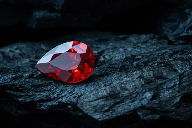 Photo of Red ruby on black coal background