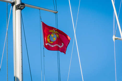 Sandwich, Massachusetts-USA -October 19, 2021- The United States Marine Corps flag is displayed proudly from the mast and rigging of a sailboat at the Sandwich Marina on a bright autumn afternoon.