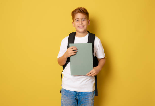 istock Happy school boy isolated over yellow background. 1347777883
