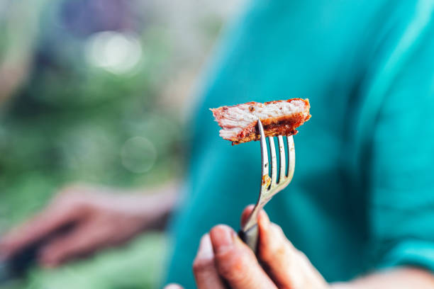 piece of rib eye steak on fork, shallow focus