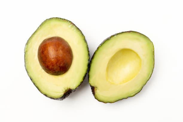 istock Avocado with cut in half isolated on white background 1347783583