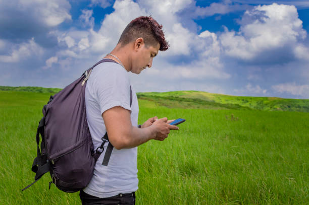 istock Man calling by cell phone, young man in the field calling by cell phone, young backpacker with cell phone in the field and copy space 1347786530