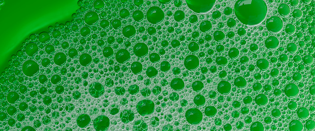 Green bubble banner, soap foam with green liquid. Flat lay top view