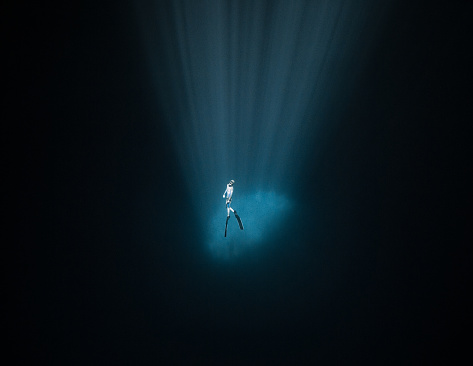 A Japanese freediver inside the sunlight that bounce off a cloud at 30 meters deep in a Mexican Cenote