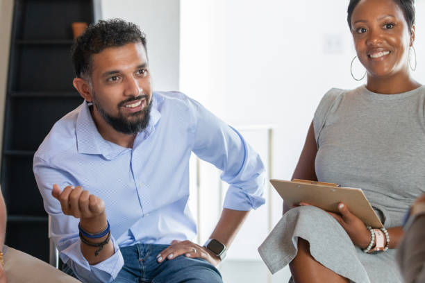 istock Diverse adults discuss ideas during support group meeting with therapist 1347798375