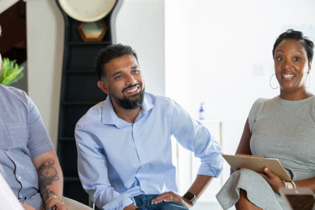 istock Smiling Man listening in group therapy meeting 1347798380