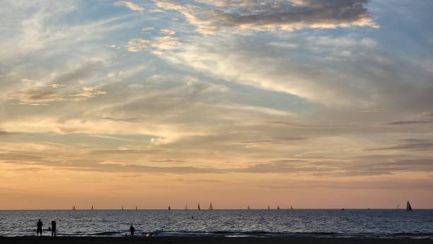 istock Three figures in silhouette with pastel sunset and white clouds . 1347800410