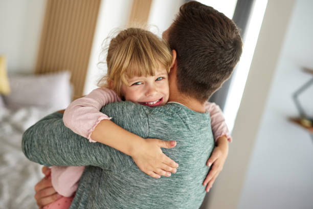 istock Father embracing a little daughter at home 1347800455