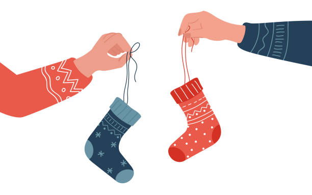 handhaltender weihnachtsstrumpf mit traditioneller süßer leckerei, weihnachtsmannsocke hängend - nikolaus stiefel stock-grafiken, -clipart, -cartoons und -symbole