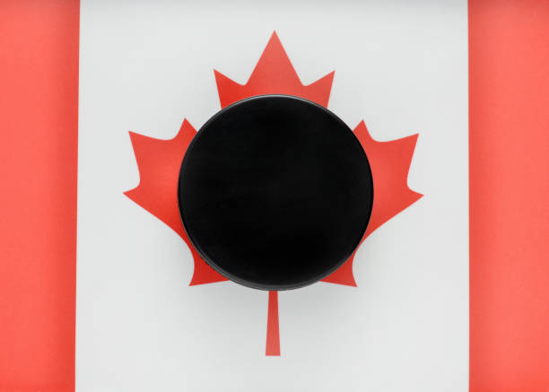 Closeup of a hockey puck on the Canadian flag symbolizing hockey in Canada.
