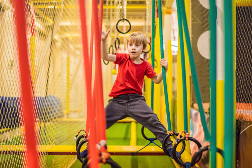 Retrato de un niño de 6 años con casco y escalada. Niño en curso de abstáculo en parque infantil de aventura photo