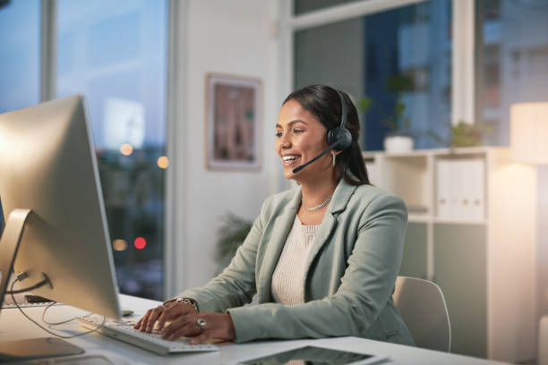 istock Shot of a young woman using a computer and headset in a modern office 1347814971