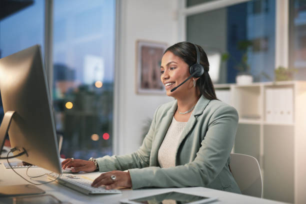 istock Shot of a young woman using a computer and headset in a modern office 1347814980