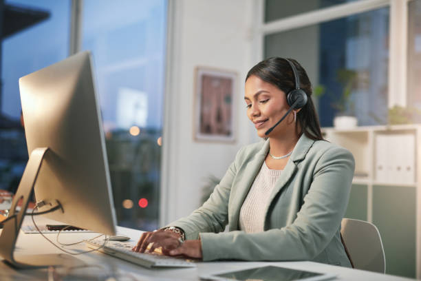 istock Shot of a young woman using a computer and headset in a modern office 1347814987