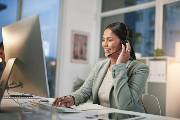istock Shot of a young woman using a computer and headset in a modern office 1347814990
