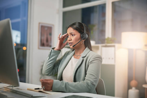 istock Shot of a young woman using a headset and looking stressed in a modern office 1347814997