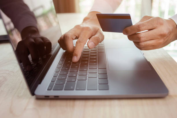 istock Male hand holding credit card and using laptop. 1347815764