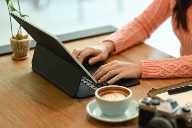 istock Close view woman in warm clothes working with computer tablet. 1347819757