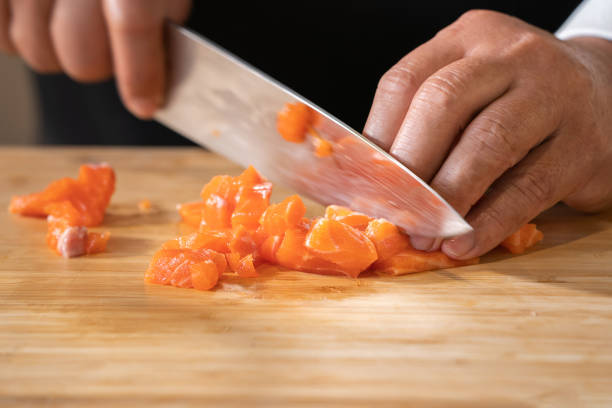 istock Close up to Slicing Cube Salmon by motion movement Knife by Prefessional Chef. 1347821201