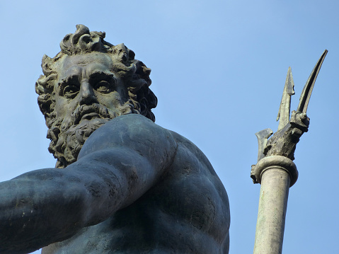 State of Neptune with the trident, closeup. Fountain of Neptune located near Piazza Maggiore in Bologna. Italy.